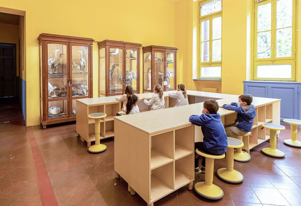 One of the classrooms opened and connected to the shared leaning zone, with new desks and stools, photo by Erich Invernizzi